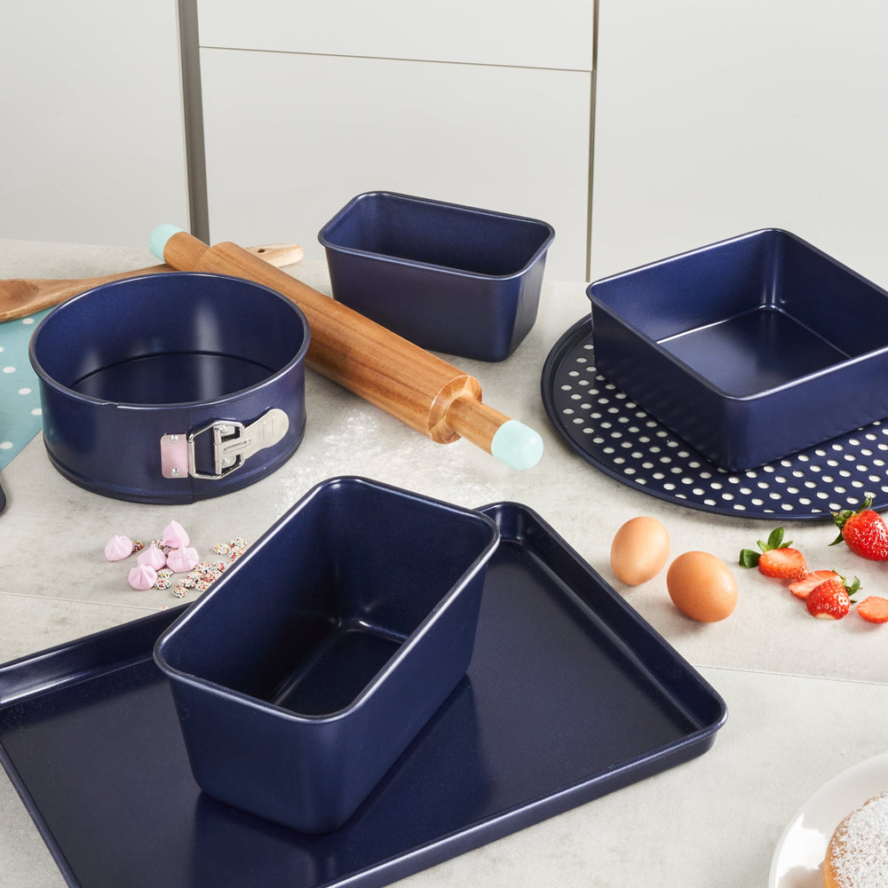 A round, dark Zyliss Durable Non-Stick Removable Base Cake Pan with high sides sits on a light surface, empty. Its smooth nonstick interior ensures easy release and effortless cleanup.