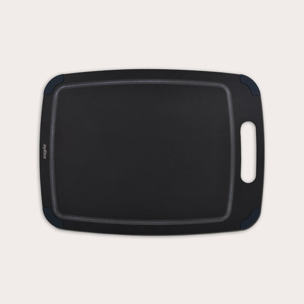 The Zyliss Wood Fibre Cutting Board, black and rectangular with a handle and rounded corners, made from recycled wood fibres, is shown on a light background. #Large