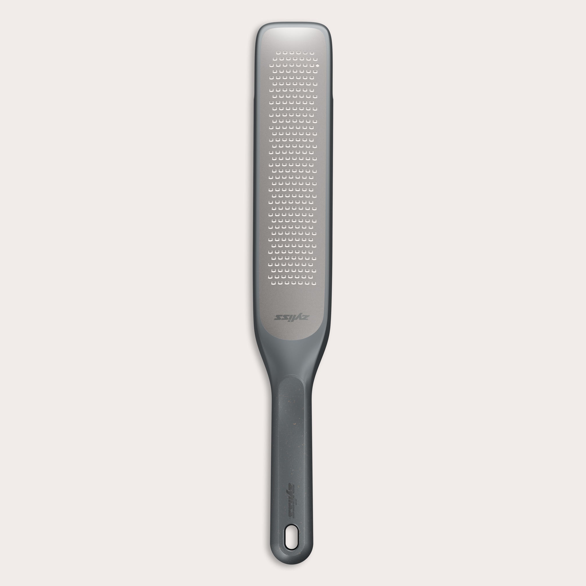 The Zyliss Rasp Grater is a long, rectangular foot file with a gray handle and textured metal surface for removing calluses and dead skin. The handle features a hanging hole for easy storage. 