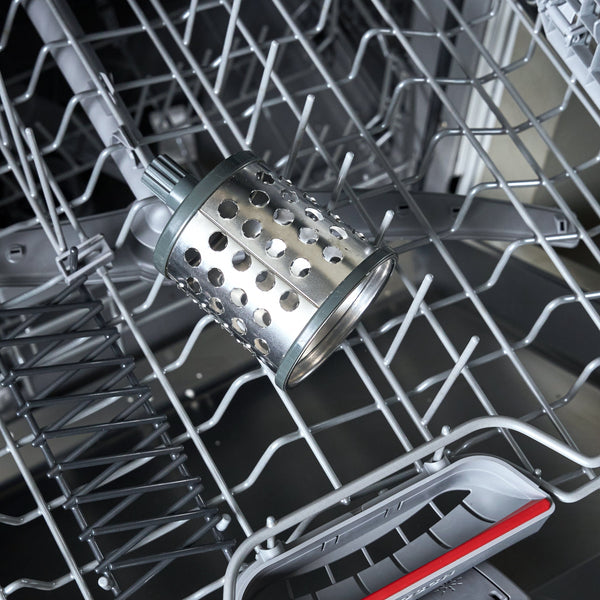 Close-up of a dishwasher interior with metal wire racks, a stainless steel basket, and a gray detergent drawer with a red accent strip.