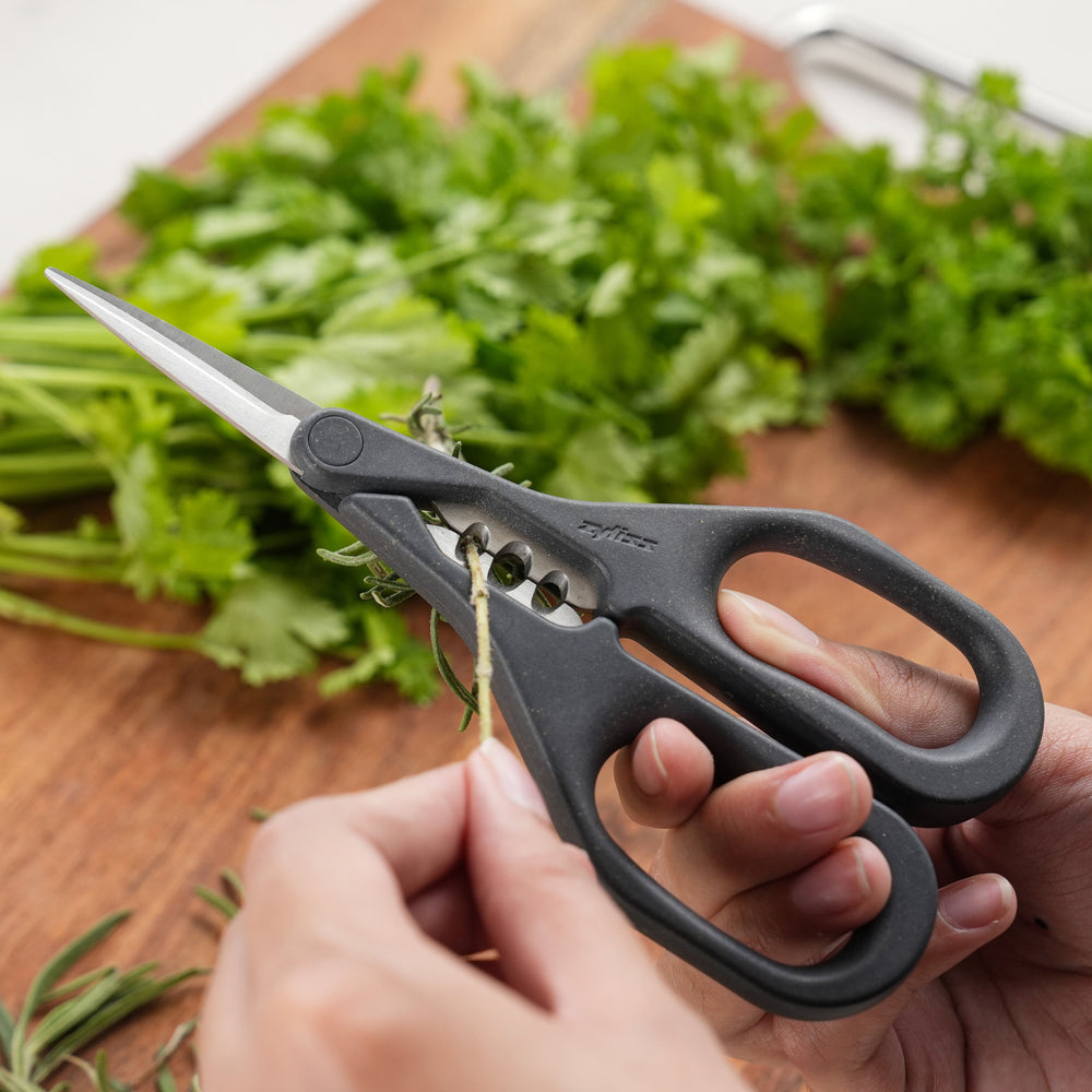 The Zyliss Herb Snippers feature dark gray handles and stainless steel blades, displayed against a plain light background.