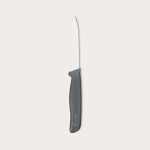 The Zyliss Paring Knife Serrated 10cm / 4, featuring a black ergonomic handle and eco-friendly material, is displayed against a plain white background. 