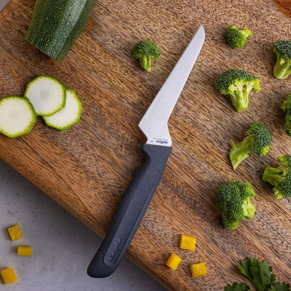 The Zyliss Offset Knife 10cm / 4 features a sharp, angled blade and an eco-friendly, ergonomic black handle, displayed vertically against a plain white background for precise cutting tasks. 