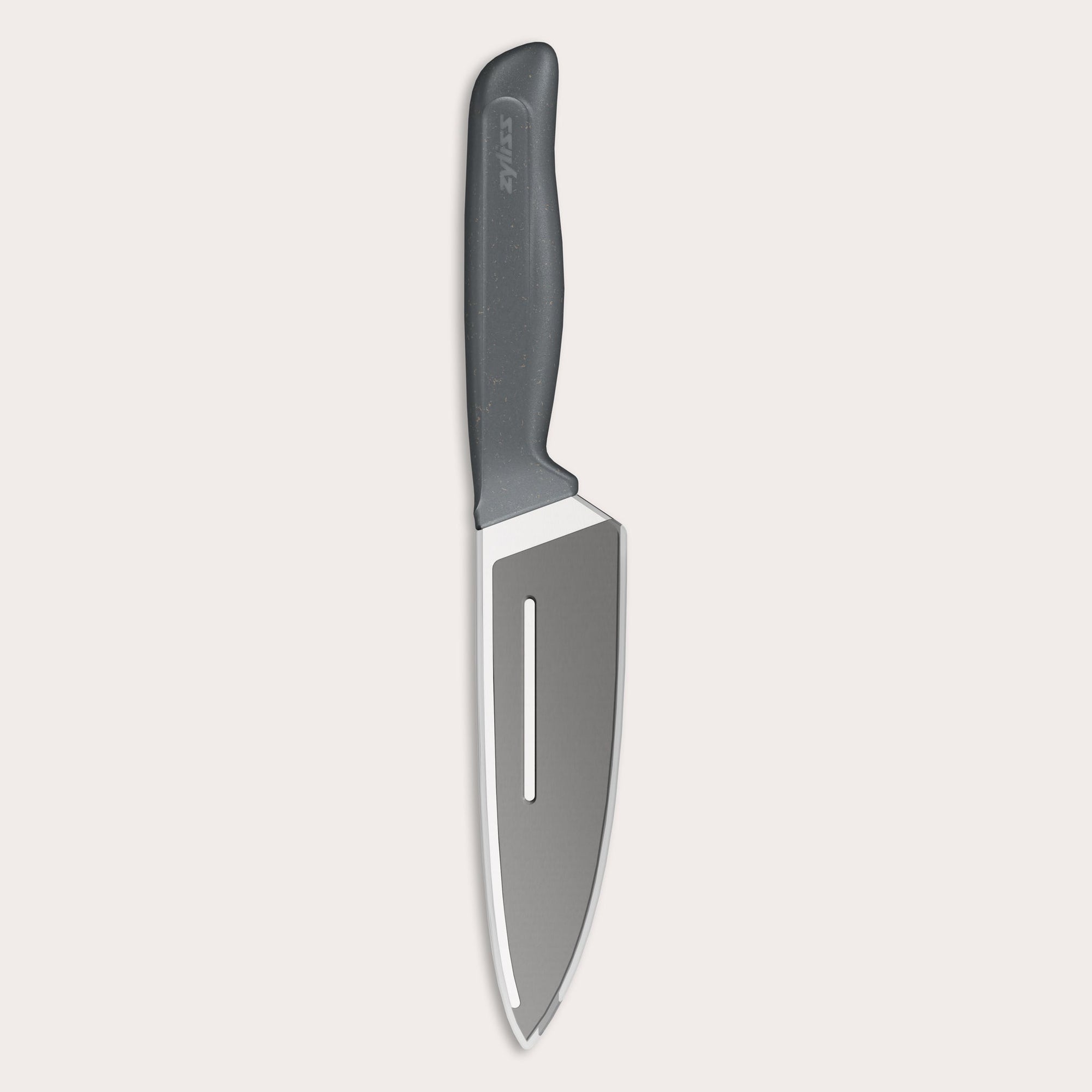 A chef’s knife with a black handle and a shiny stainless steel blade, shown on a plain light background. The blade has a straight edge with a hollow groove running parallel to the edge.