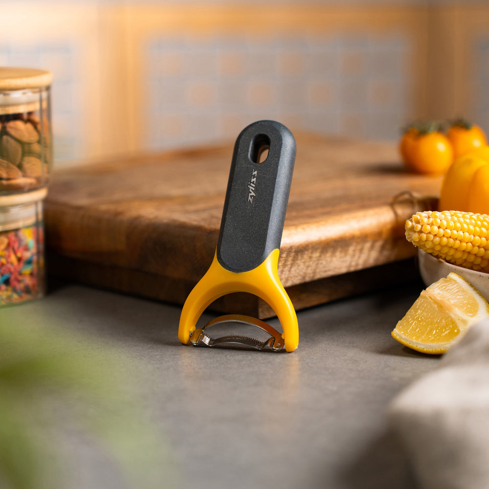 The Zyliss Corn Stripper, featuring a yellow and gray ergonomic handle and wide horizontal stainless steel blade for easy kernel removal, is shown on a plain white background. 