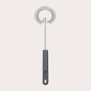 The Zyliss Gravy Whisk features a metal spiral and a dark plastic handle with a hanging hole. It is heat-resistant and shown against a plain light background.