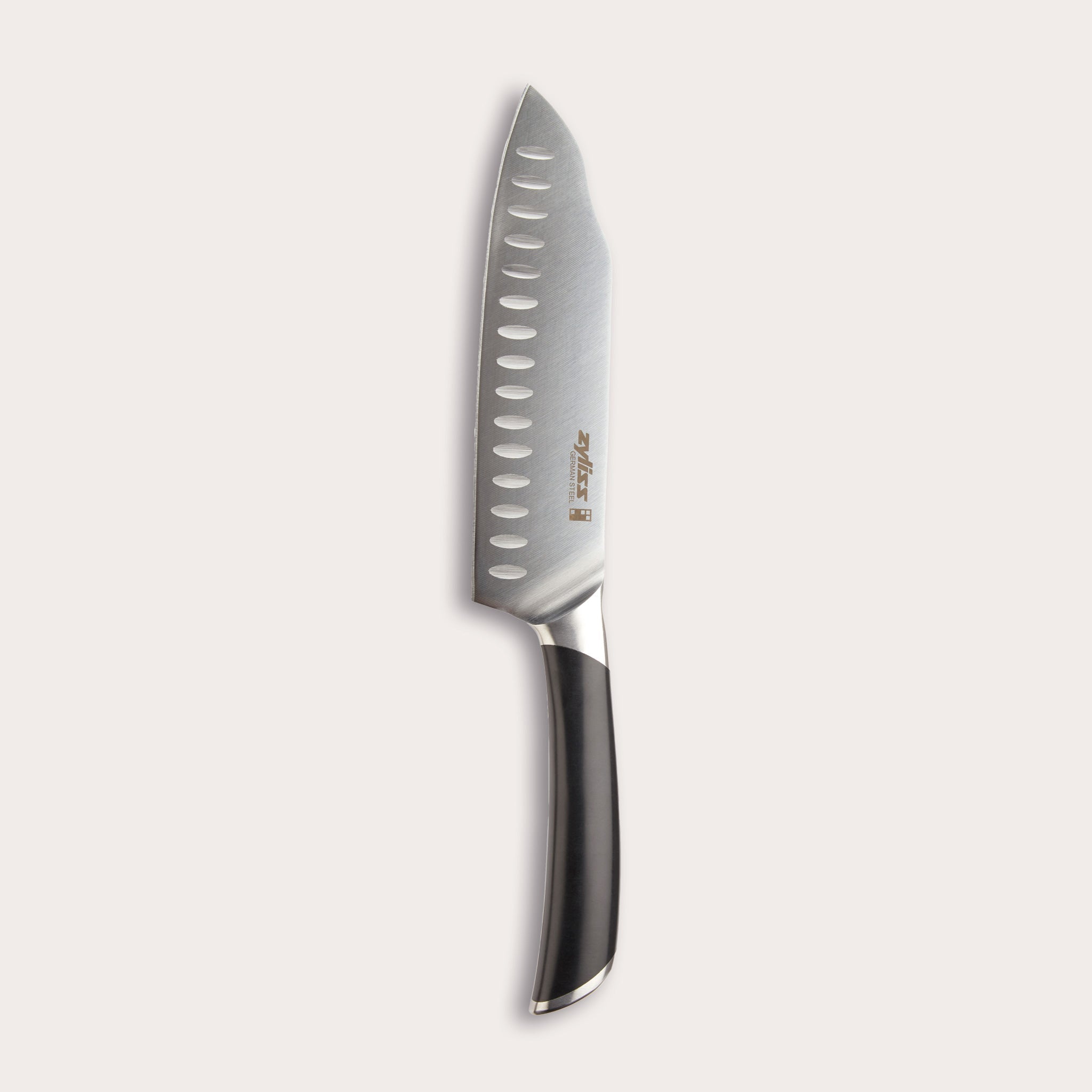 The Zyliss Comfort Pro Santoku Knife 18cm/7 features German stainless steel, a black ergonomic handle, and oval blade indentations, displayed against a light background. 